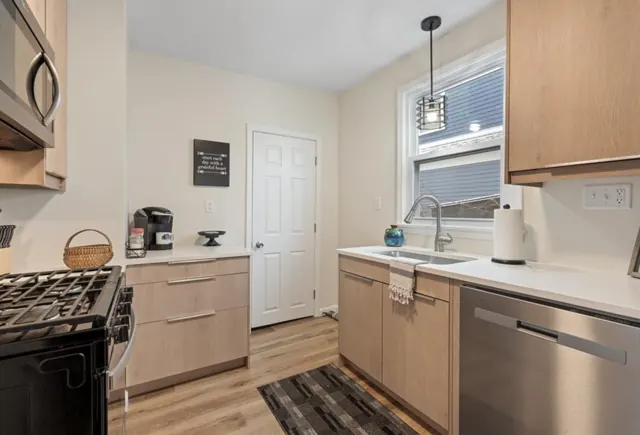 Galley kitchen with slab cabinets, gas range and new flooring, St. Paul, MN